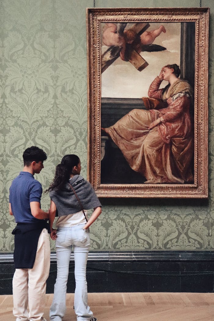 Services A young couple observing classic artwork in a London art museum, highlighting cultural appreciation.
